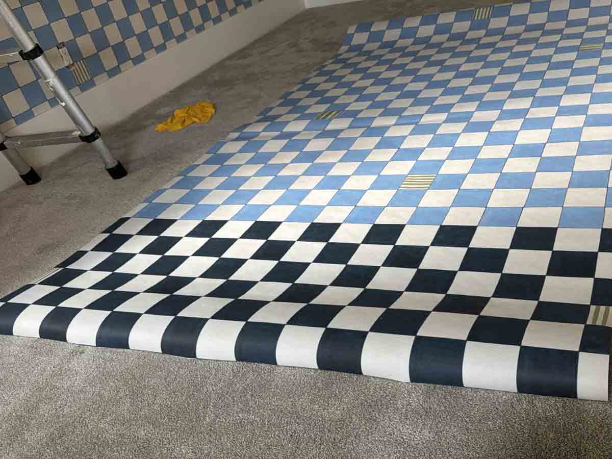 Checkered vinyl wallpaper installation process unrolling patterned wallcovering Denver metro area