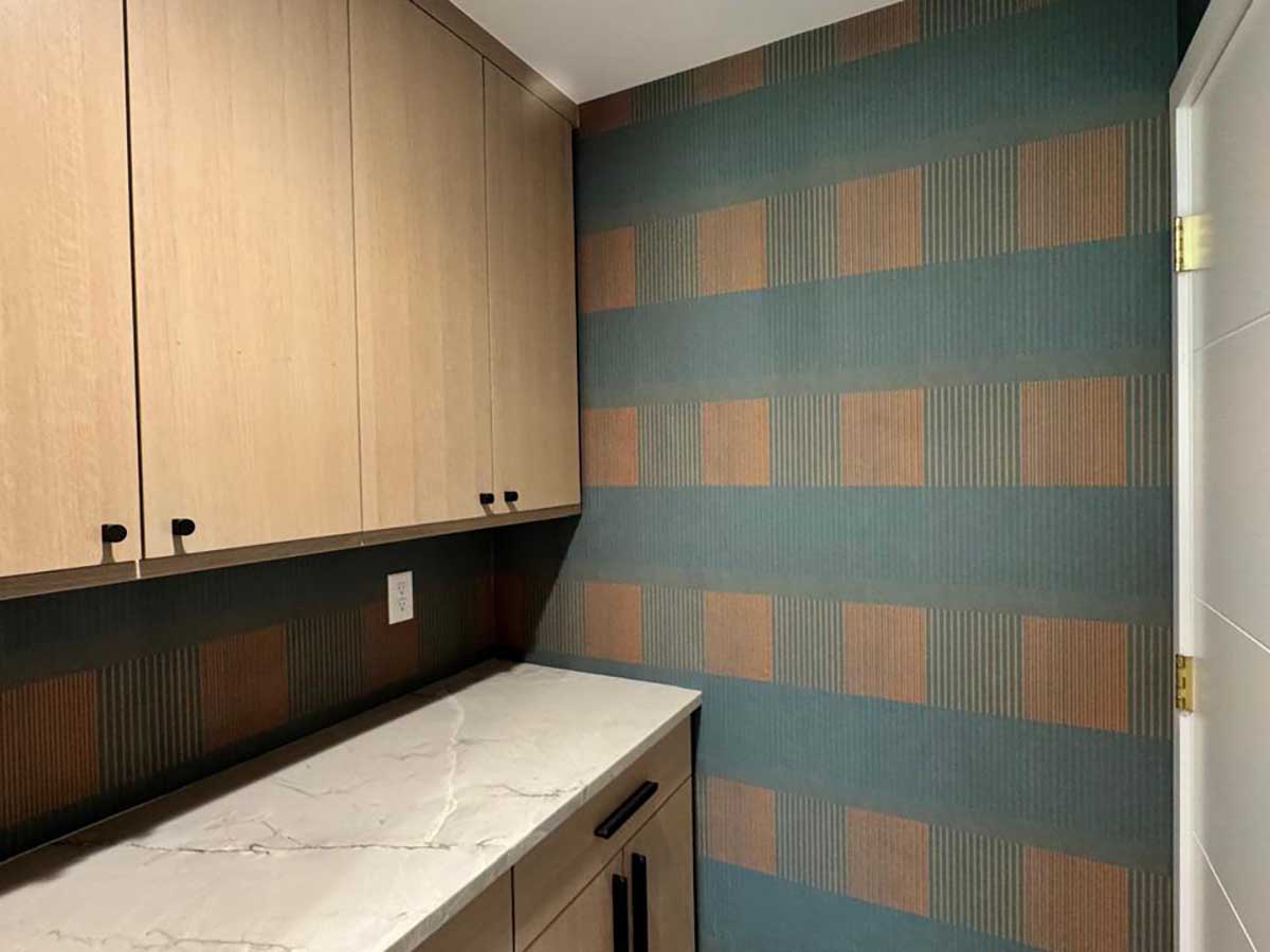 Laundry room wallpaper installation in Denver metro area with geometric pattern and precise cutting around cabinets