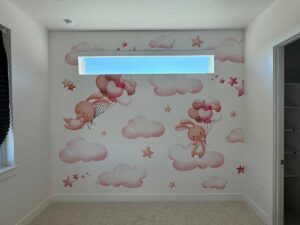 Kids room wall mural installation in Denver metro area with clouds, stars and bunny illustration design