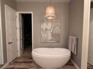 Bathroom wallcovering installation in Denver metro area with neutral textured finish around freestanding bathtub