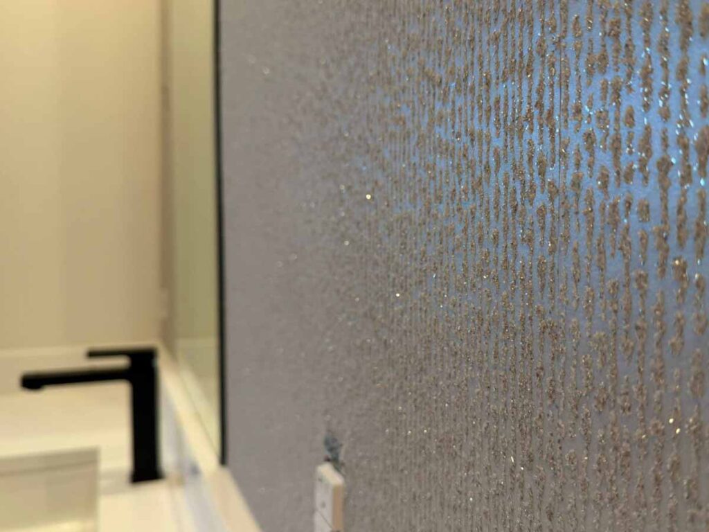 Textured wallcovering installation in a bathroom in the Denver metro area with vertical metallic pattern and moisture-resistant finish