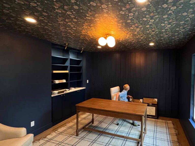 Professional wallpaper installation in Castle Pines, Colorado featuring a floral wallpaper ceiling and dark modern home office with custom wall paneling and built-in shelving.