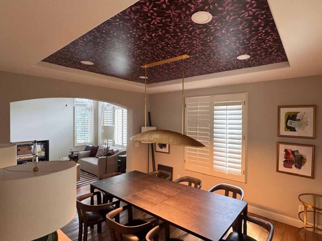 Ceiling wallpaper installation in Denver metro area dining room with bold patterned inset tray ceiling design