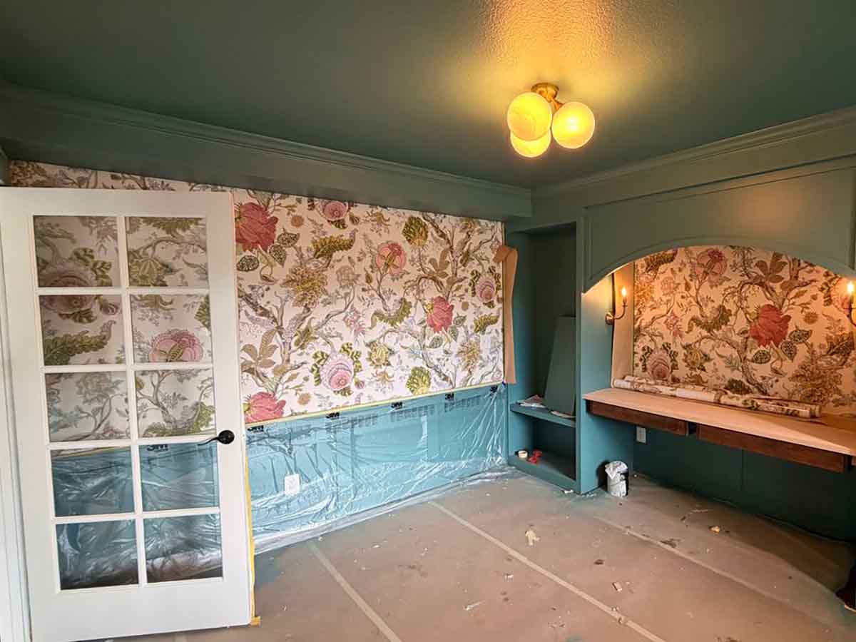 Professional floral wallpaper installation in Durango, Colorado featuring a colorful botanical accent wall in a custom home office with built-in shelving.