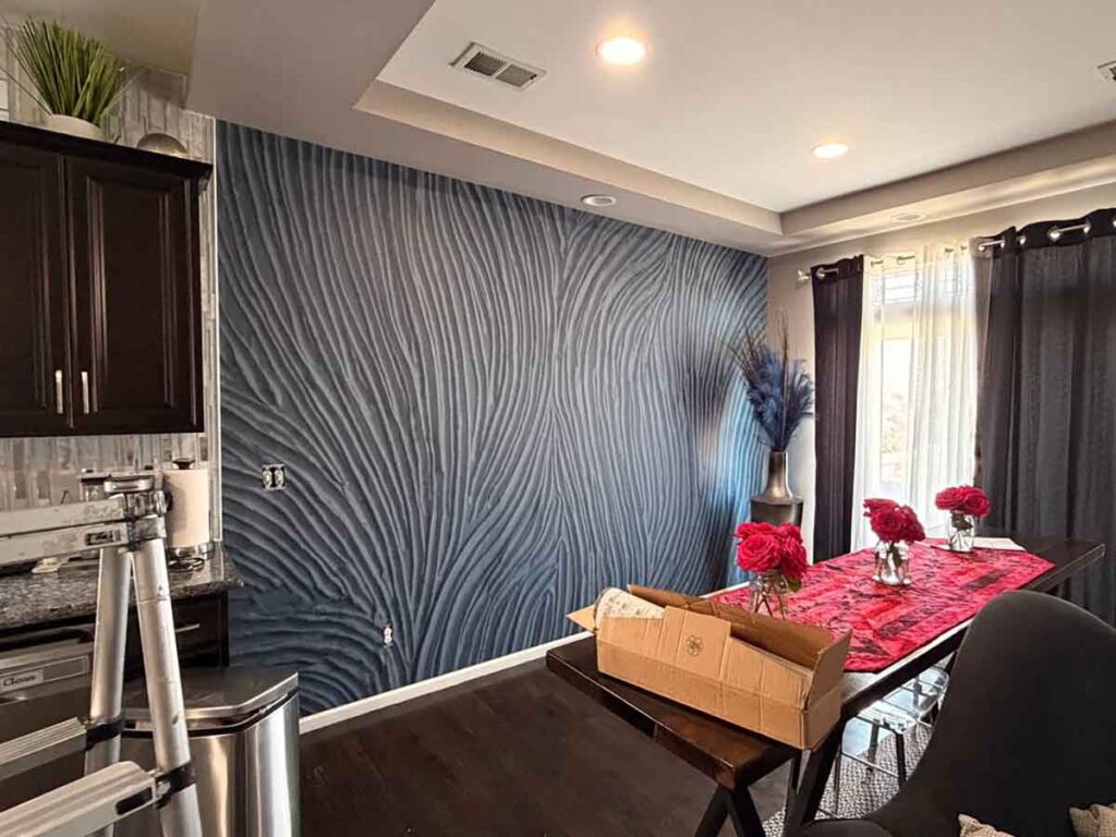 Professional mural wallpaper installation in Erie, Colorado featuring a modern blue textured wall mural in a dining room with seamless panel alignment.