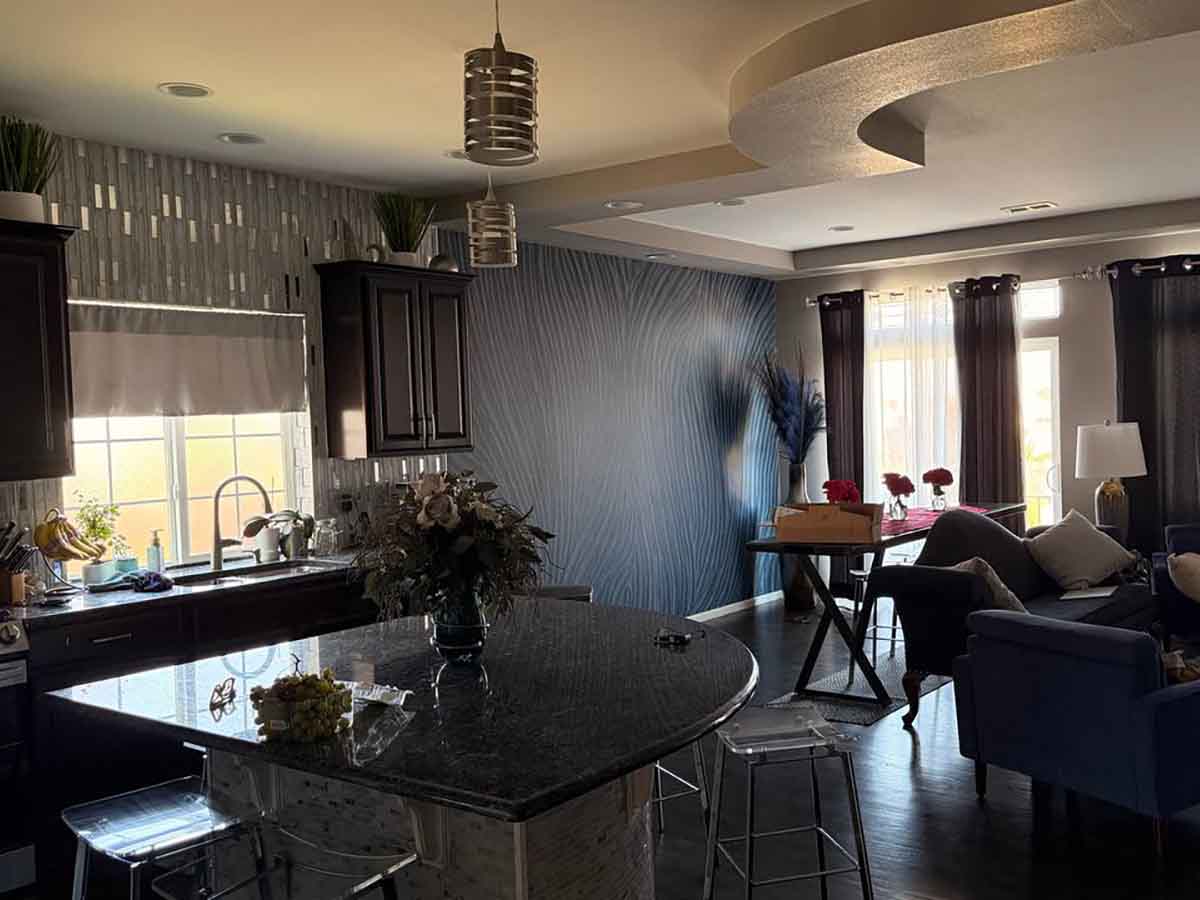Professional wall mural installation in Estes Park, Colorado featuring a modern blue abstract feature wall connecting the kitchen, dining, and living areas.