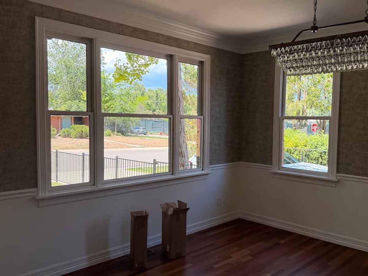 Professional grasscloth wallpaper installation in Evans, Colorado featuring a sophisticated dining room with natural textured wallcovering and seamless finishing around windows and trim.