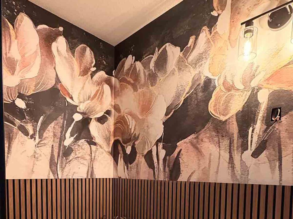 Professional floral wall mural installation in Florence, Colorado featuring a dramatic oversized botanical mural paired with modern wood slat wall panels in a luxury powder room.