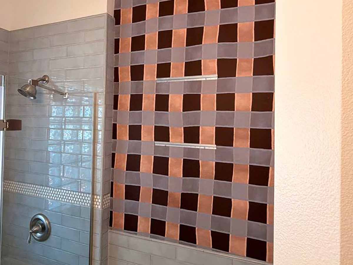 Geometric checkerboard wallpaper installation Fort Lupton CO bathroom accent wall terracotta mauve shower adjacent Weld County Colorado