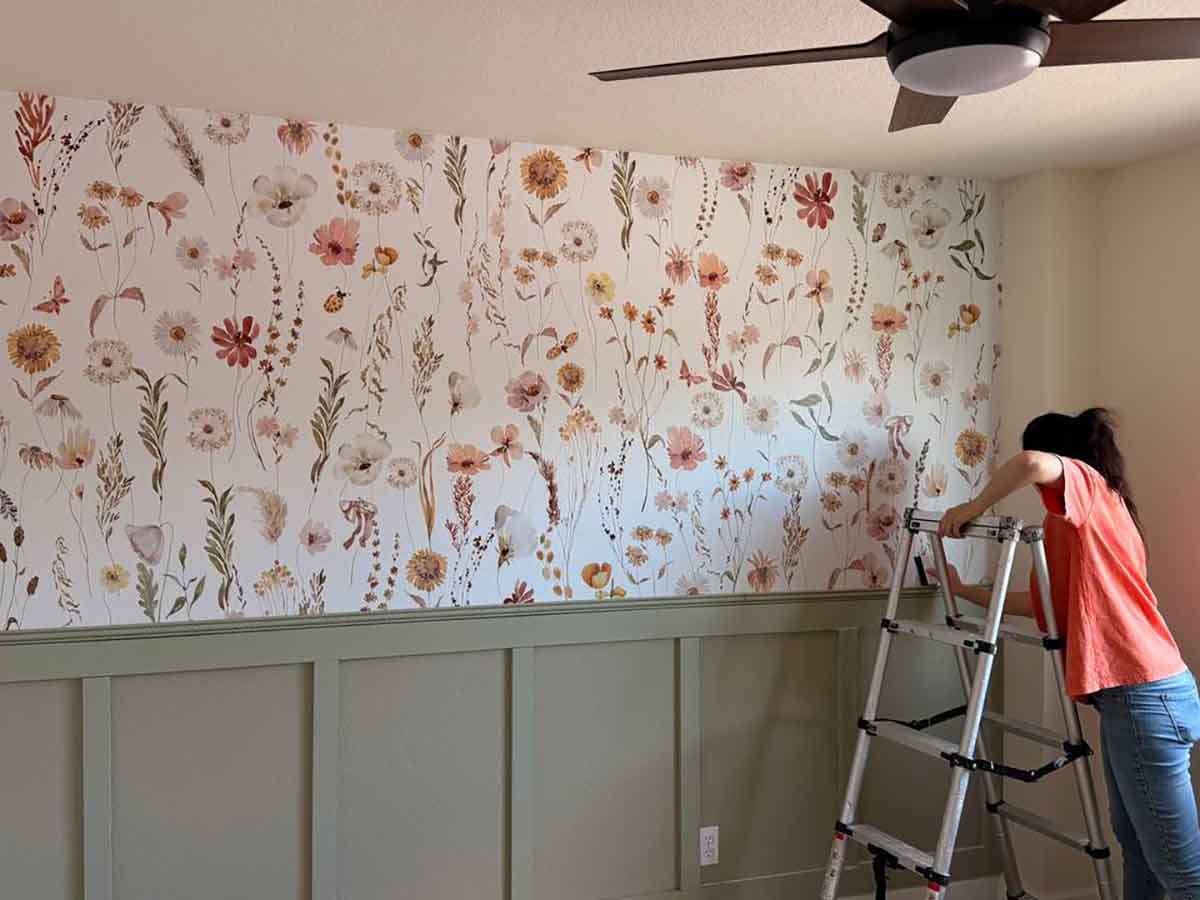 Professional floral wallpaper installation in Fort Morgan, Colorado featuring a botanical accent wall above custom board and batten wainscoting in a bedroom.