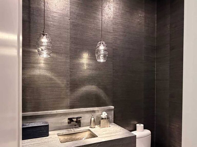 Professional grasscloth wallpaper installation in Georgetown, Colorado featuring a luxury powder room with dark textured wallcovering and a modern floating vanity.