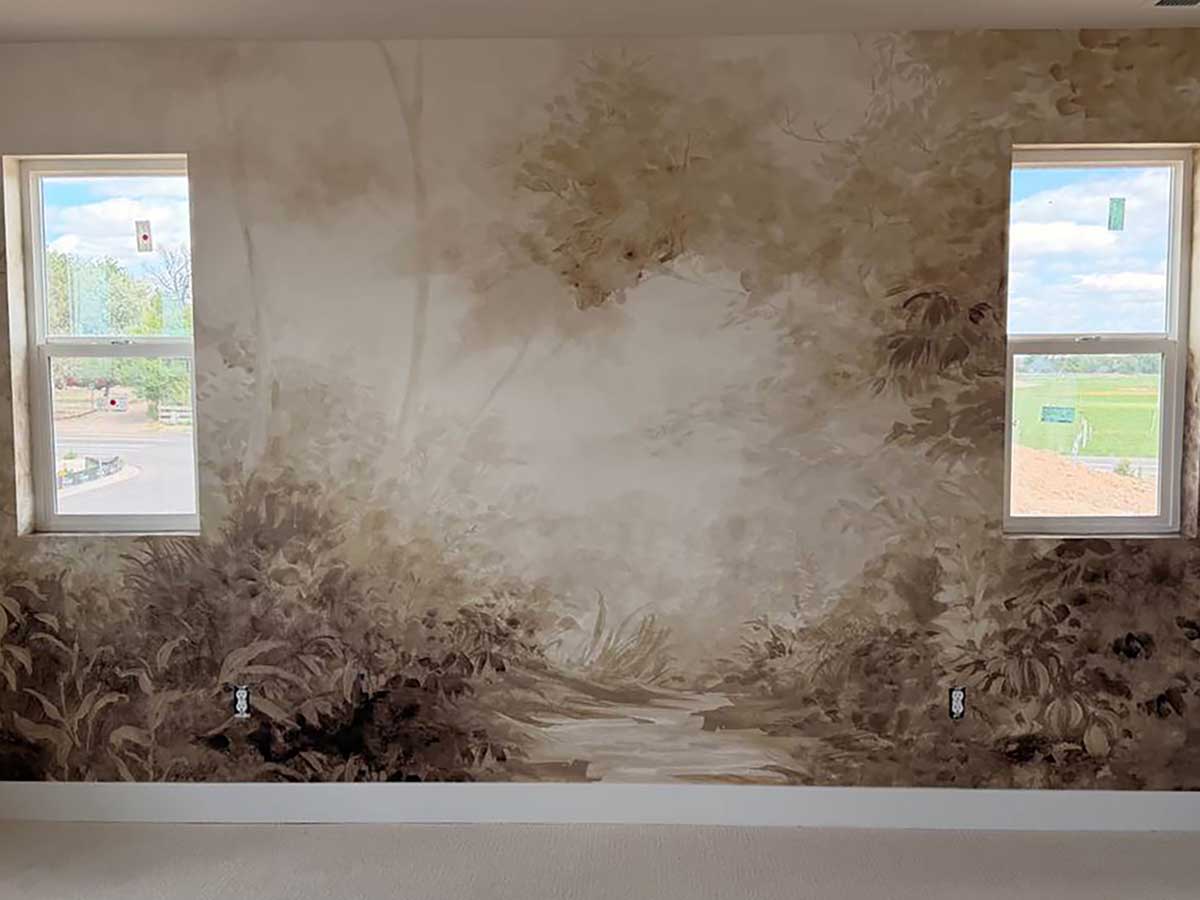 Custom forest mural wallpaper installation in Grand Junction, Colorado featuring a panoramic woodland landscape between two windows with seamless pattern alignment.