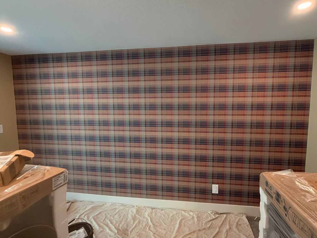 Plaid wallpaper installation in Lafayette, Colorado featuring a classic tartan pattern on a large accent wall with perfectly aligned horizontal and vertical lines.