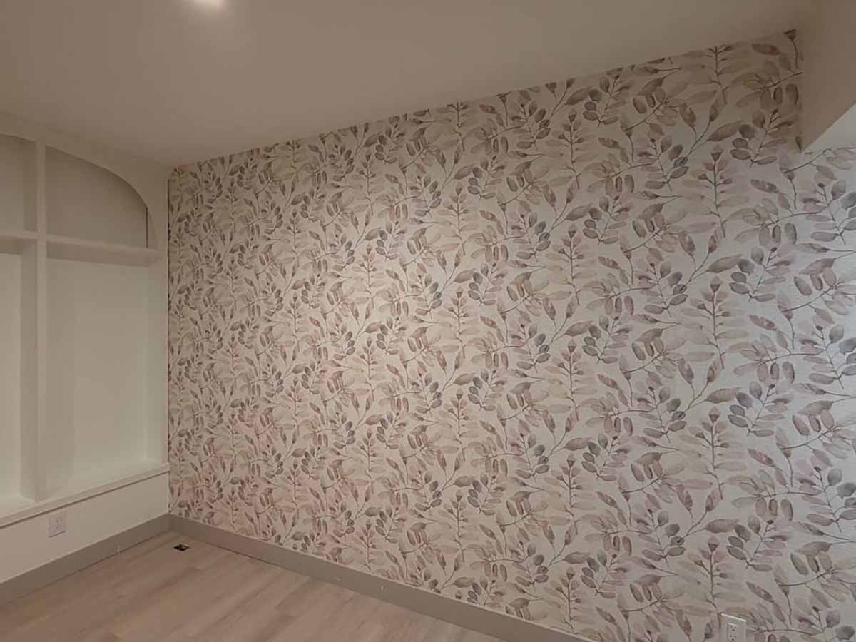 Accent wall wallpaper installation in Loveland, Colorado featuring a soft botanical leaf pattern in warm neutral tones, professionally installed with seamless pattern matching.