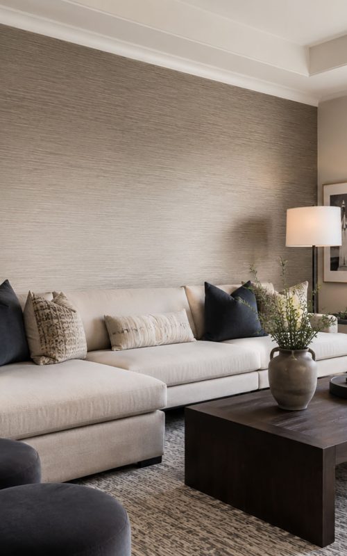 Modern living room featuring a professionally installed premium textured wallcovering accent wall in a soft neutral tone with elegant contemporary furnishings and abundant natural light.